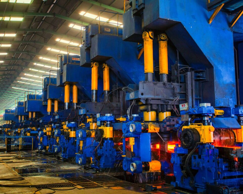 A large industrial facility with automated machinery and workers monitoring production
