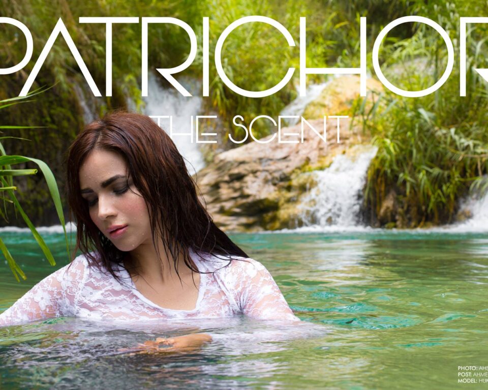 A woman with wet brown hair and a white lace top emerges from clear green water in a natural setting with waterfalls and lush greenery in the background, promoting 'PATRICHOR THE SCENT' as editorial fashion photography by Ahsan Ali Shahid